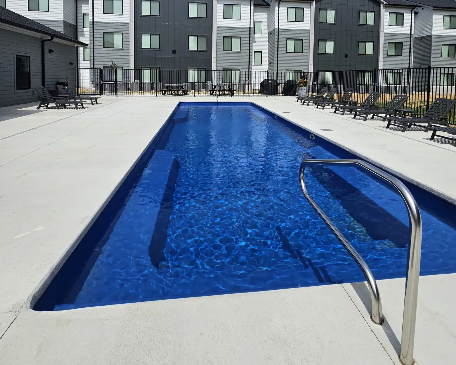 Resort-style pool with lounge chairs in the District Flats courtyard